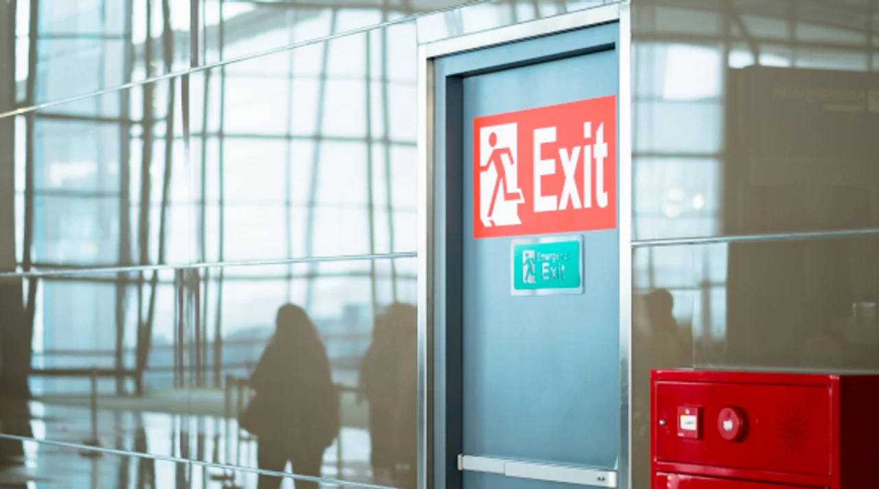 Emergency exit door with illuminated exit signs in a modern office building